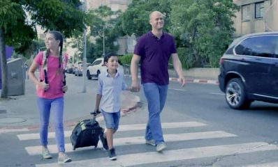 אדם מלווה ילד במעבר חצייה. צילום: דוברות עיריית הרצליה