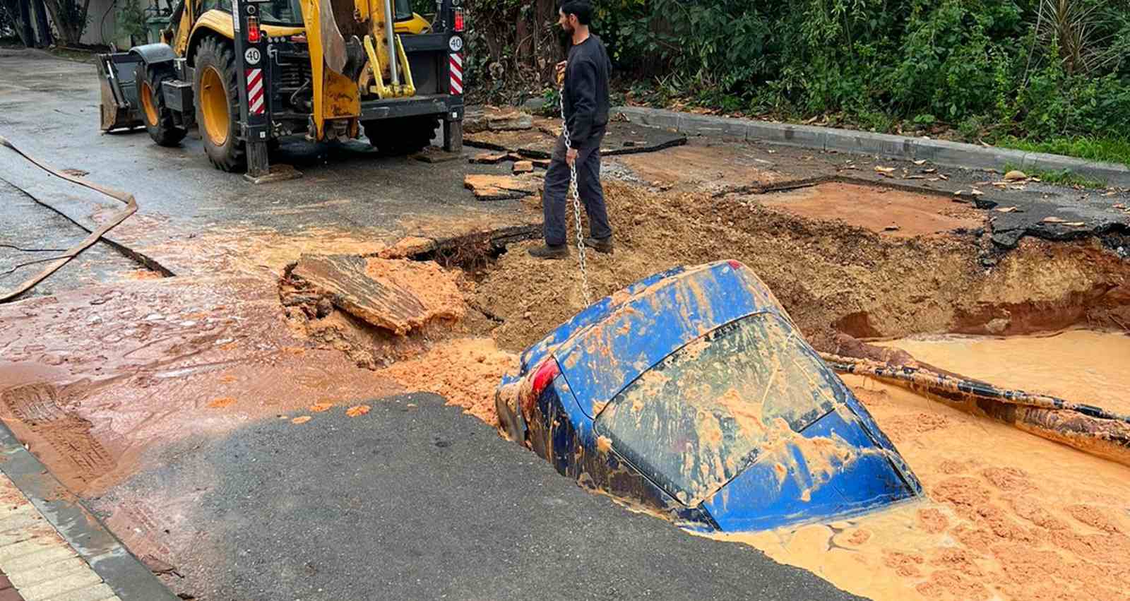 המכונית בתוך הבולען בהוד השרון. צילום: דוברות המשטרה