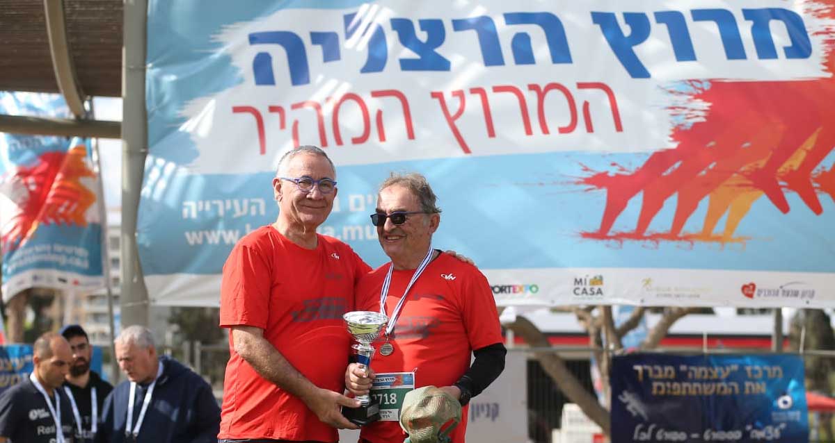 ראש עיריית הרצליה, משה פדלון (משמאל), מעניק גביע לאלי קינדלר (מימין). צילום: דוברות עיריית הרצליה