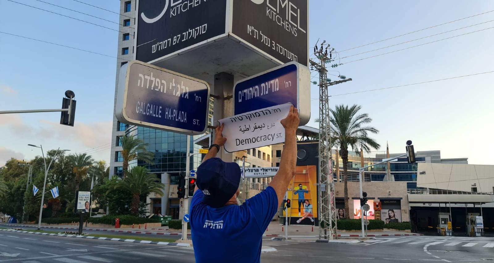 תליית השלטים בצומת הרחובות מדינת היהודים וגלגלי הפלדה. צילום: מטה המאבק הדמוקרטי הרצליה