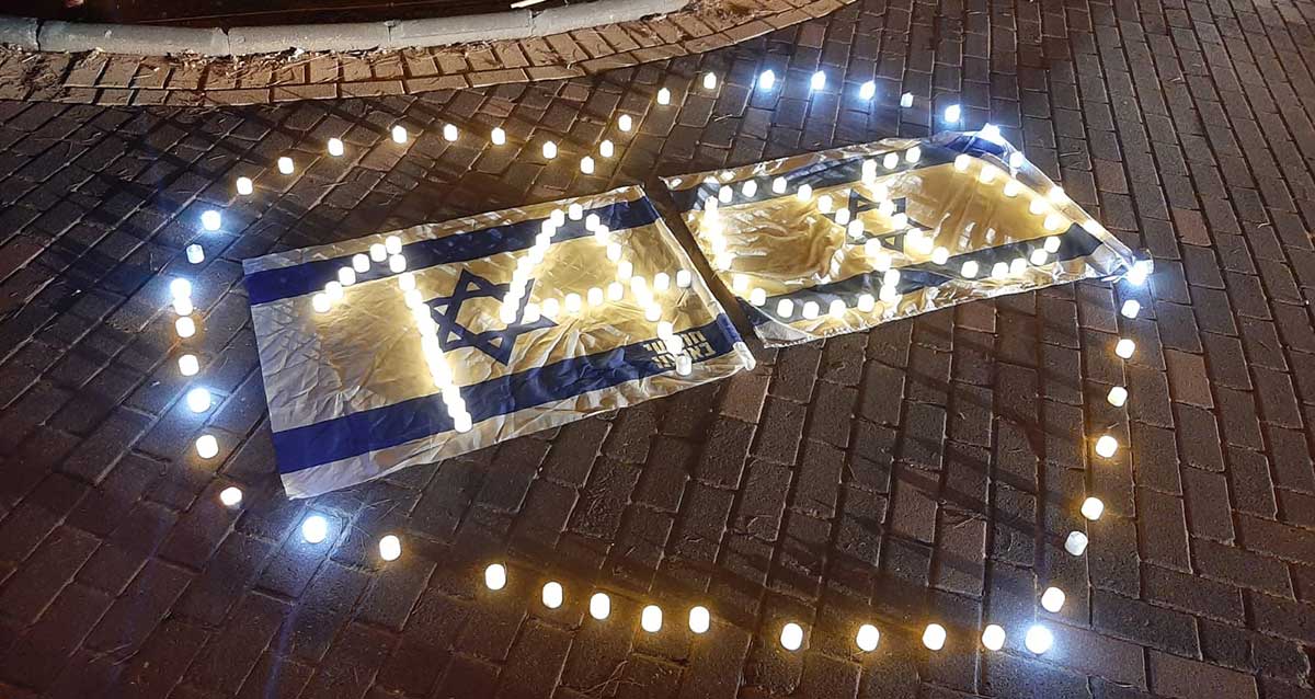 הדלקת נרות לזכר הנרצחים והנרצחות מול ביתו של קיש בהוד השרון