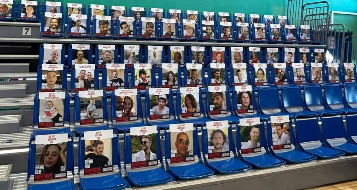 הכיסאות הריקים באולם היובל עם תמונות החטופים