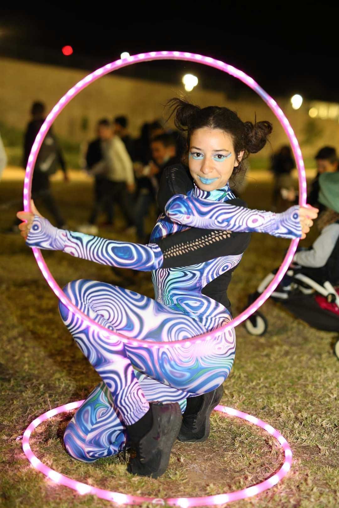 לוליינית חישוקים מוארים בחוף הים של הרצליה