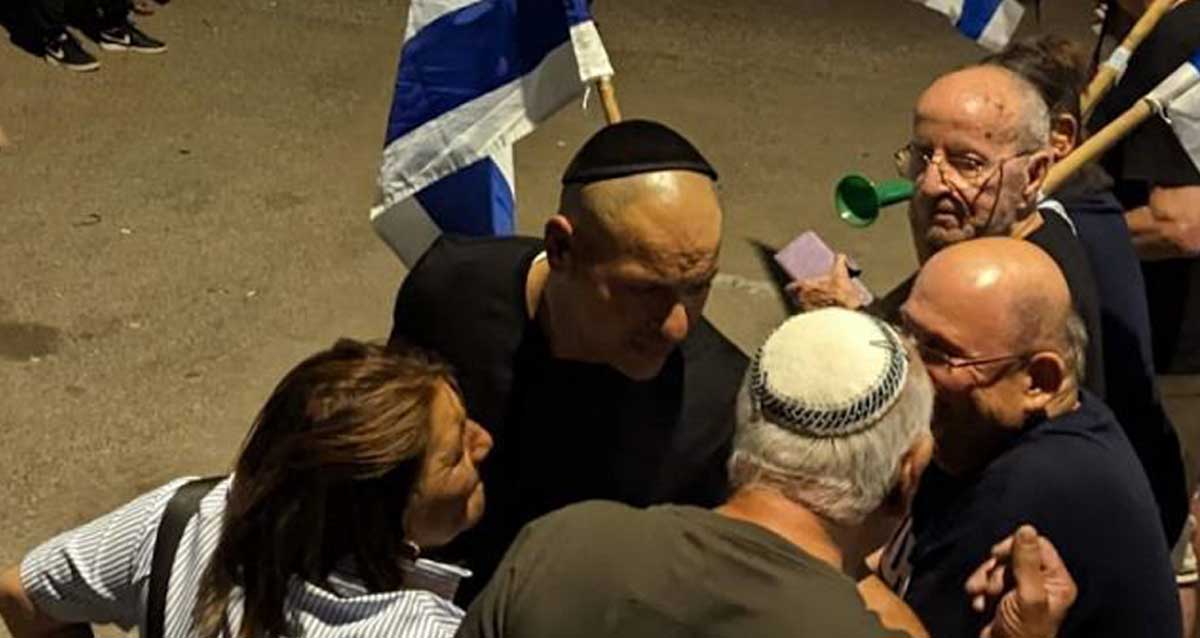 אופיר לוזון מול מפגינים באירוע השקה של רפי קדושים