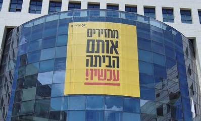 באנר ענק בחזית בניין עיריית הרצליה: מחזירים אותם הביתה עכשיו
