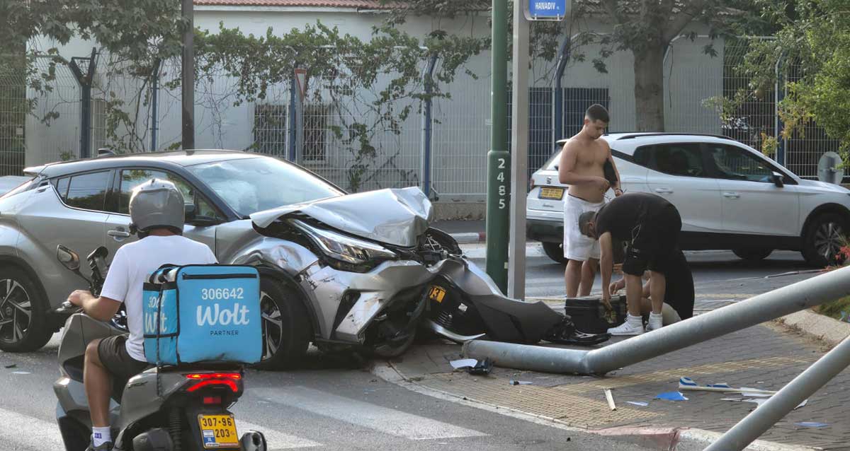 תאונת דרכים בהרצליה. מטפלים בנפגעים. מכונית שוברת תמרור דרכים