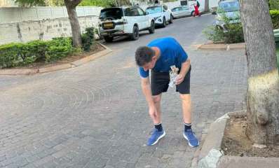 יריב פישר אוסף בדלי סיגריות שהשליכו המפגינים מול ביתו. צילום: עיריית הרצליה צילום: פרטי