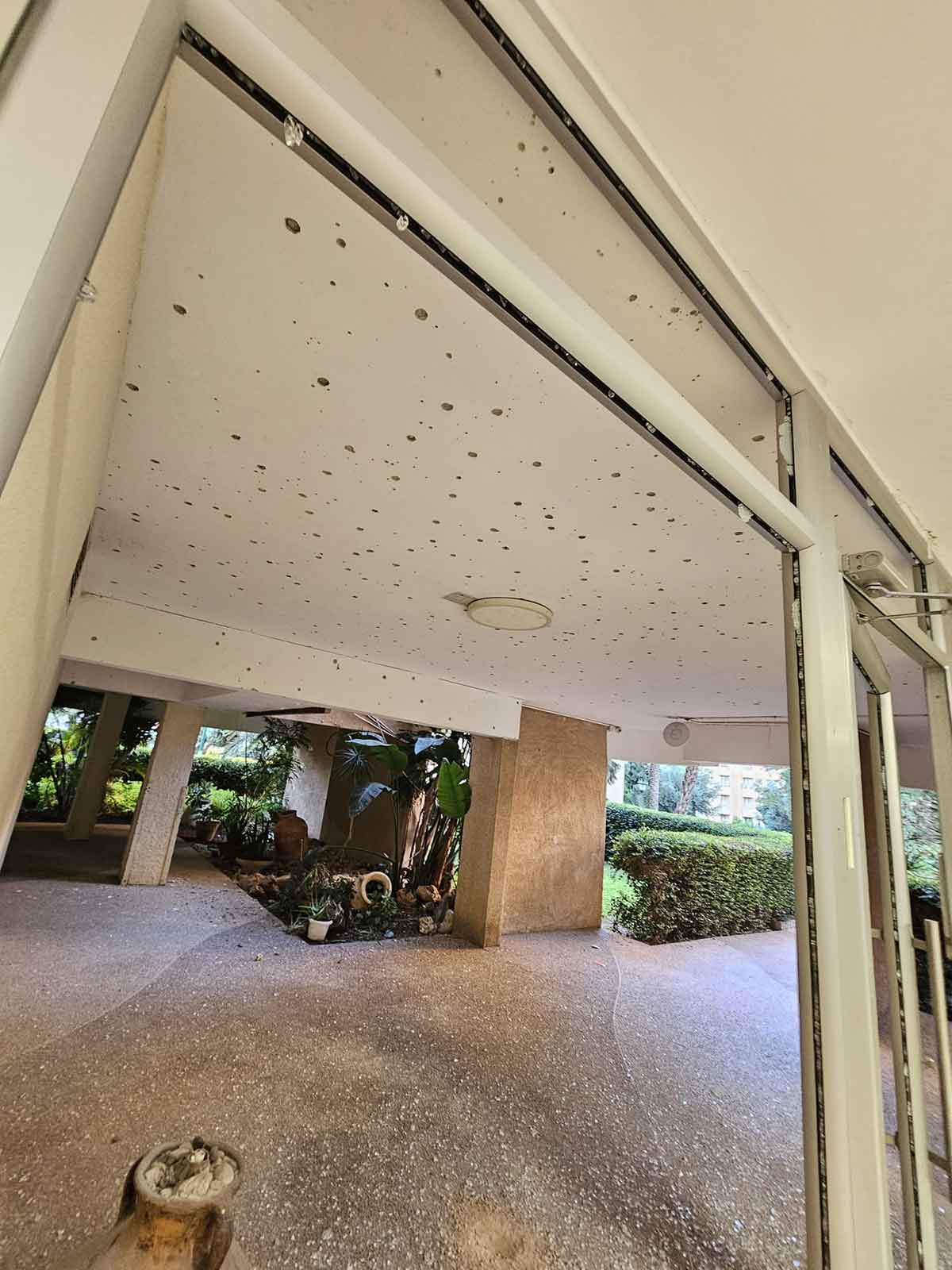 לובי בניין בבר כוכבא 119, הרצליה. הזכוכיות מנופצות והתקרה מחוררת ככל הנראה כתוצאה של פיצוץ רימון רסס