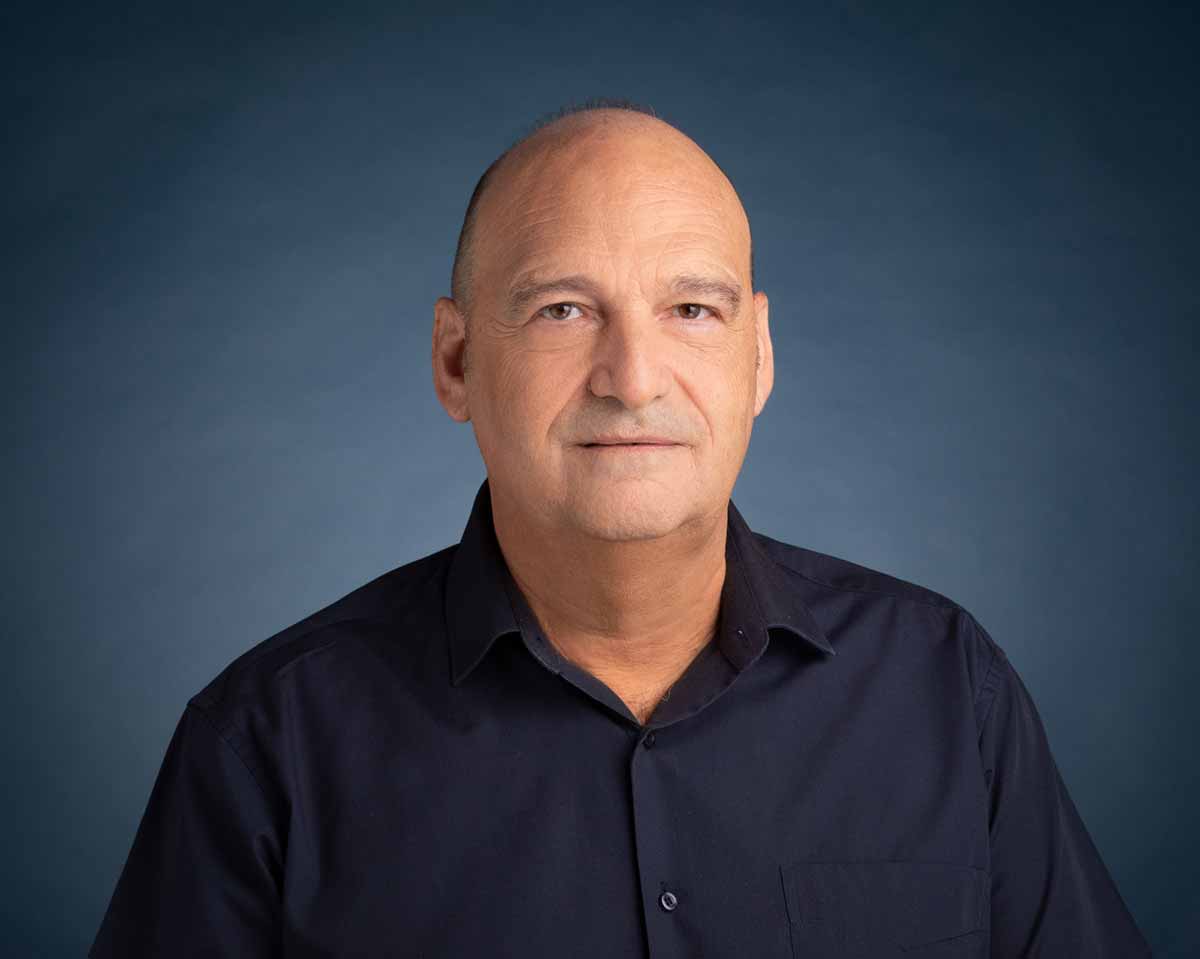 תמונה של עו"ד מיכה בלום היועץ המשפטי של עיריית רמת השרון, תמונה של חלק גוף עליון פנים וחזה. לבוש בחולצה שחורה עם כפתורים