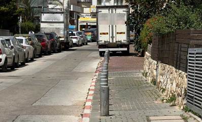 משאית חונה על מדרכה ומשאית חוסמת מעבר ברחוב רופין