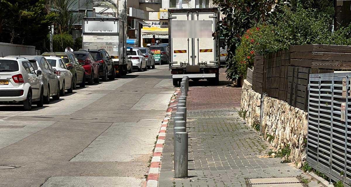 משאית חונה על מדרכה ומשאית חוסמת מעבר ברחוב רופין