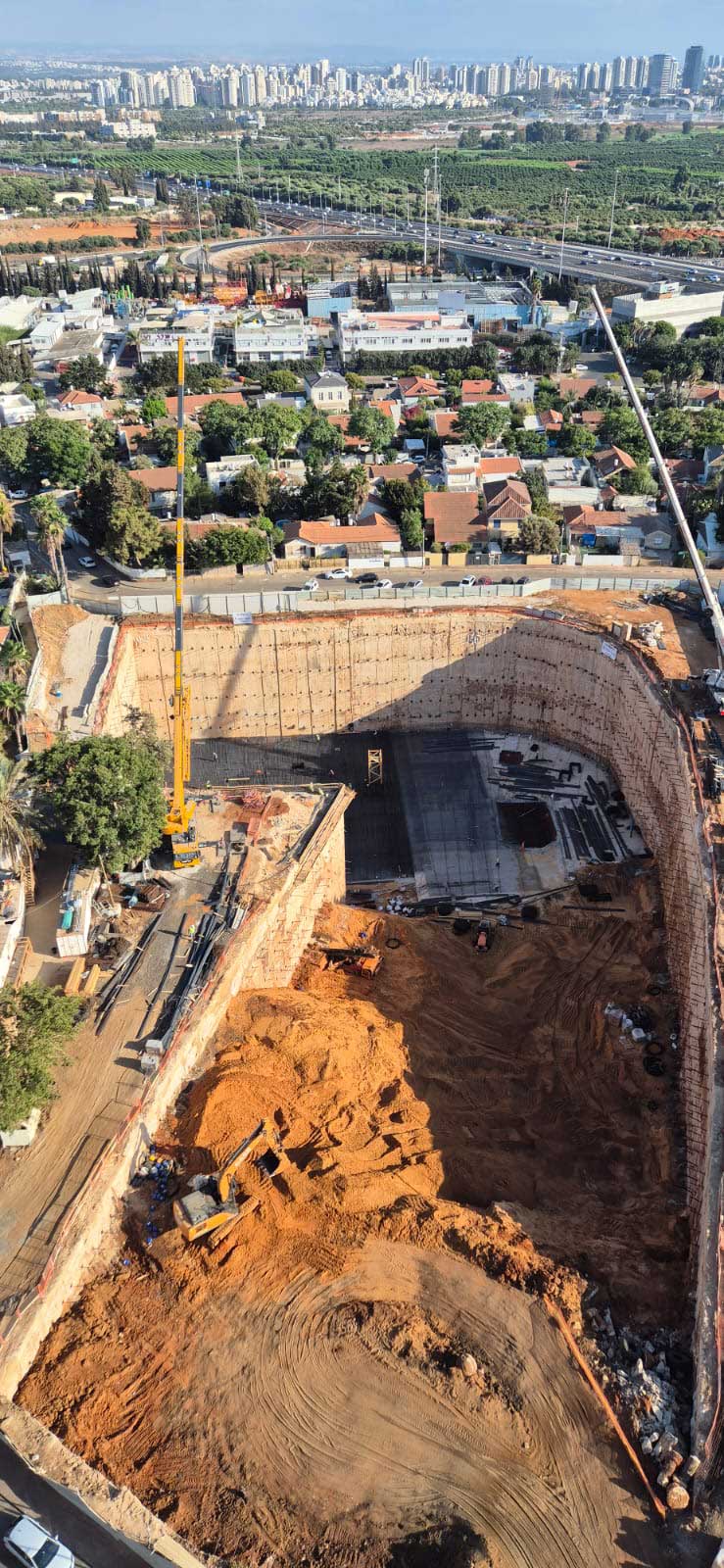 הבור בעומק חמש קומות, שבו יוקמו ארבעה מגדלים, עם 450 דירות נוספות בפרויקט אאורה רמת השרון. צילום: יריב לוין