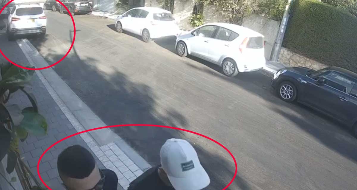 צילום מתוך וידיאו של פורצים בפעולה. אחד הפורצים מסיע את הרכב המסומן הגנוב המסומן בעיגול אדום ושניים מהפורצים מתרחקים רגלית