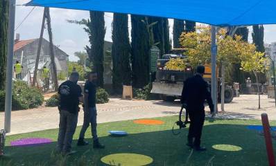 הריסת מבנה לא חוקי בכפר סבא. אני הביצוע ופקחים מתחת לסככה צופים בפועלים מצבעים את ההריסה. טרקטור ענק בצד