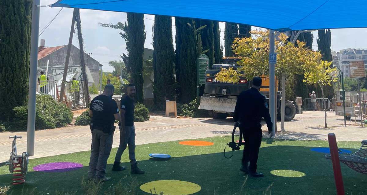 הריסת מבנה לא חוקי בכפר סבא. אני הביצוע ופקחים מתחת לסככה צופים בפועלים מצבעים את ההריסה. טרקטור ענק בצד