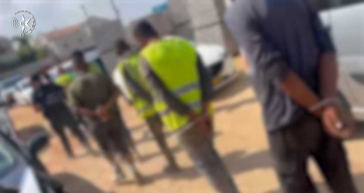 שוהים בלתי חוקיים אזוקים מאחורי הידים ומובלים לניידות המשטרה בהרצליה
