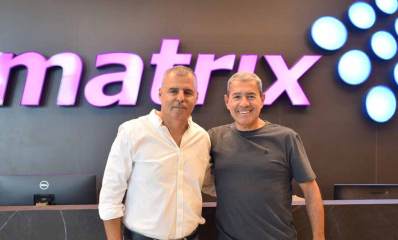 רפי סער ראש העיר כפר סבא ומוטי גוטמן מנכ"ל מטריקס במשכן החדש של מטריקס בכפר סבא. ברקע קיר עם הכיתוב מטריקס באנגלית ומימין תשעה עיגולים הלוגו של מטריקס בצבעים תכלת ולבן