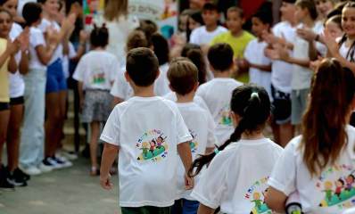 פתיחת שנת הלימודים בבית הספר לב טוב. תלמידים של כיתות גבוהות מקבלים את פניהם של תלמידי כיתה א', הלבושים בחולצות לבנות של בית הספר ובגב החולצה ציור של שלושה ילדים רוכבים על קלמר גדול וכיתוב: שלום כיתה א', לב טוב