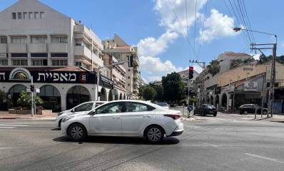 רחוב ששת הימים כפר סבא, משמאל בניין פינתי של 4 קומות ובקומת הקרקע מאפיית המשפחה. קומת הקרקע עם קשתות בשני הצדדים. הצילום הוא בצומת רחובות. בצד ימין בניין בן שתי קומות ובקומת הקרקע חנויות וקשתות בצד הבניין.