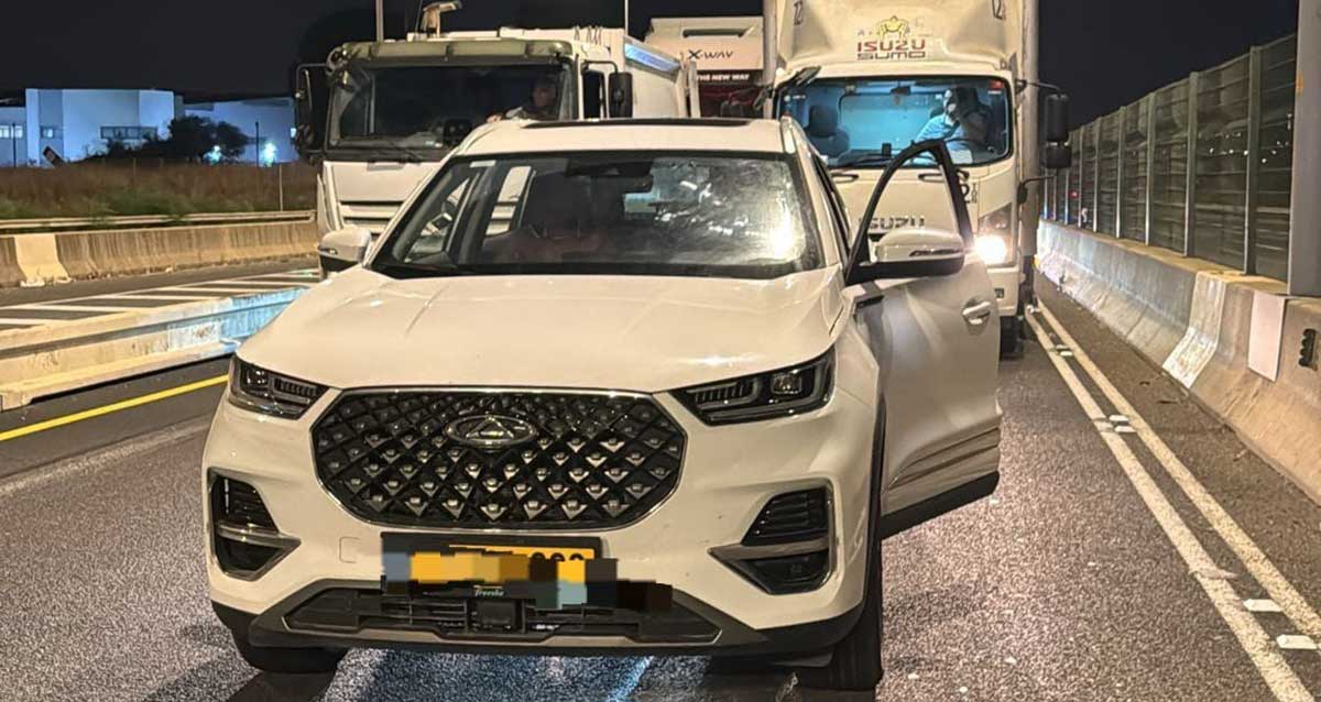 רכב גנוב שנתפס על ידי המשטרה. הדלת פתוחה ומאחוריות משאיות
