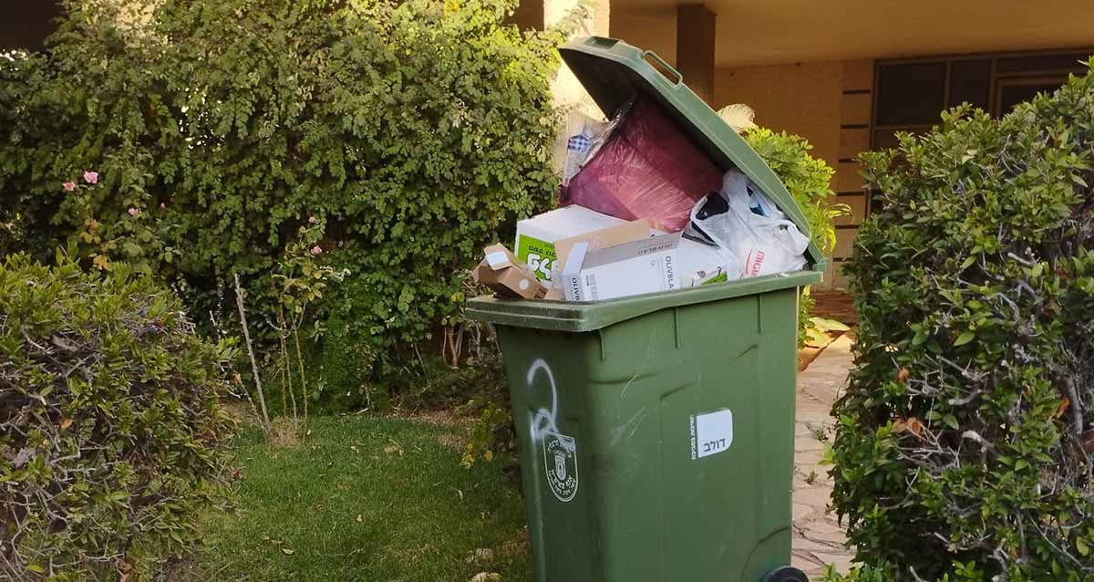 אשפה בהרצליה - בן ציון דינור 2 / גולומב 17. פח אשפה גדוש עם קרטונים ושקיות אשפה.