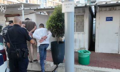 השוהים הבלתי חוקיים שנעצרו מובלים לתוך תחנת המשטרה על ידי השוטרים