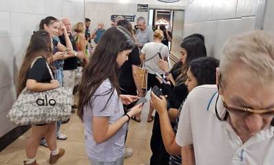 מבוגרים ובני נוער מצטופפים בכניסה למרחב המוגן בקניון שבעת הכוכבים הרצליה בזמן אזעקה
