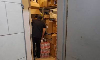 המרחב המוגן בקניון שבעת הכוכבים מלא בסחורה, ארגזים על מדפים, בקבוקי מים