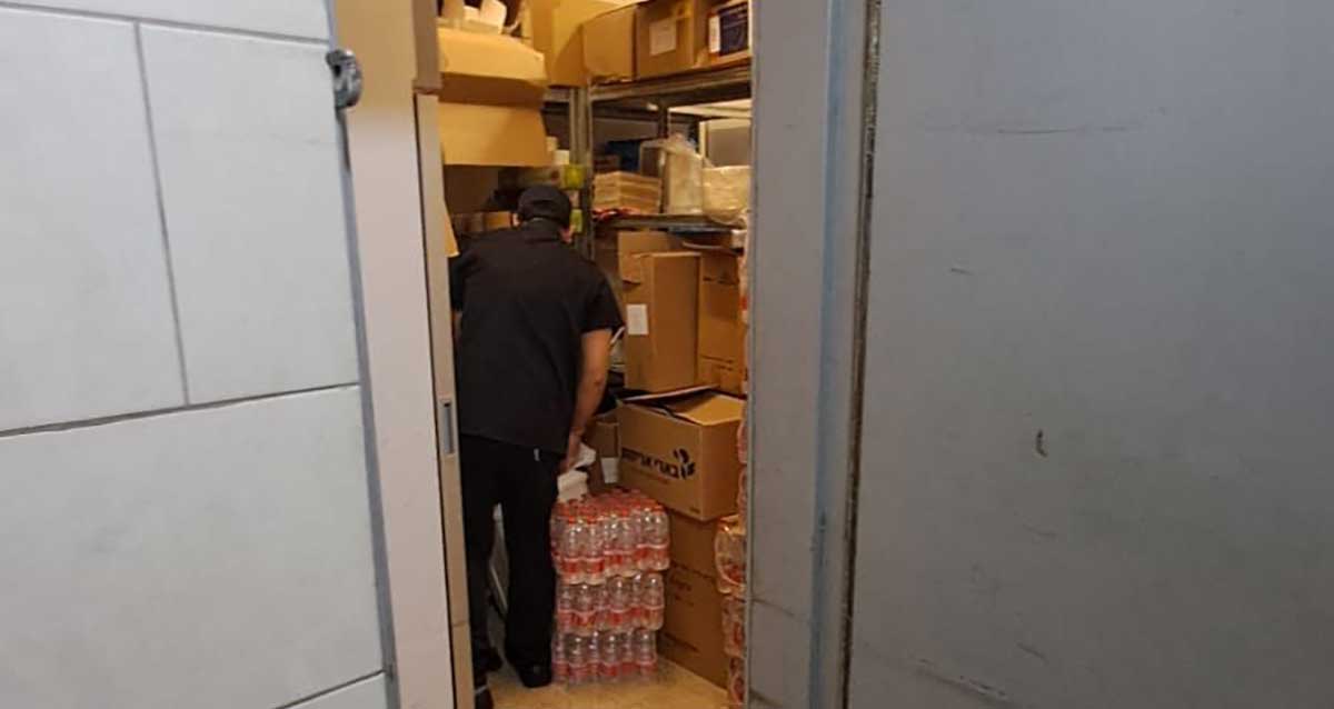 המרחב המוגן בקניון שבעת הכוכבים מלא בסחורה, ארגזים על מדפים, בקבוקי מים