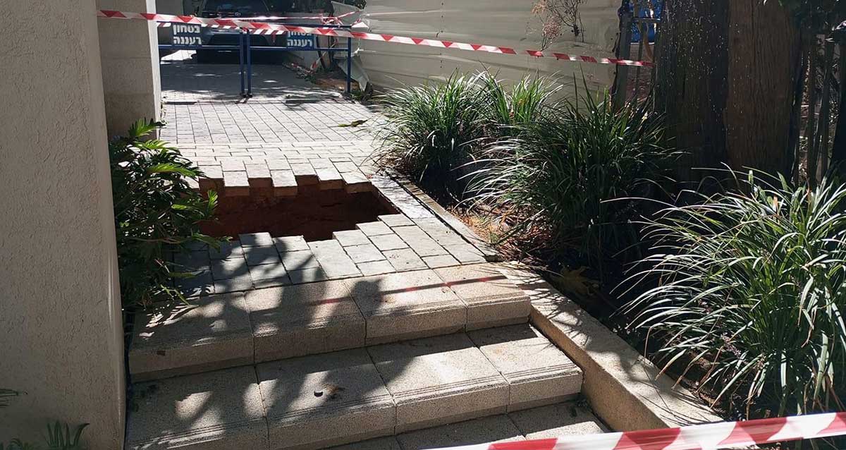 בולען שנפער בשבי הכניסה לבית ברעננה, בצד השביל שיחים. הבולען מגודר בפסי סימון אדומים לבנים וחסום עם חמסומים של בטחון רעננה