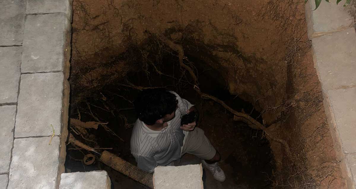 צילום של דניאל בתוך הבולען שנפער בשביל הכניסה לבניין