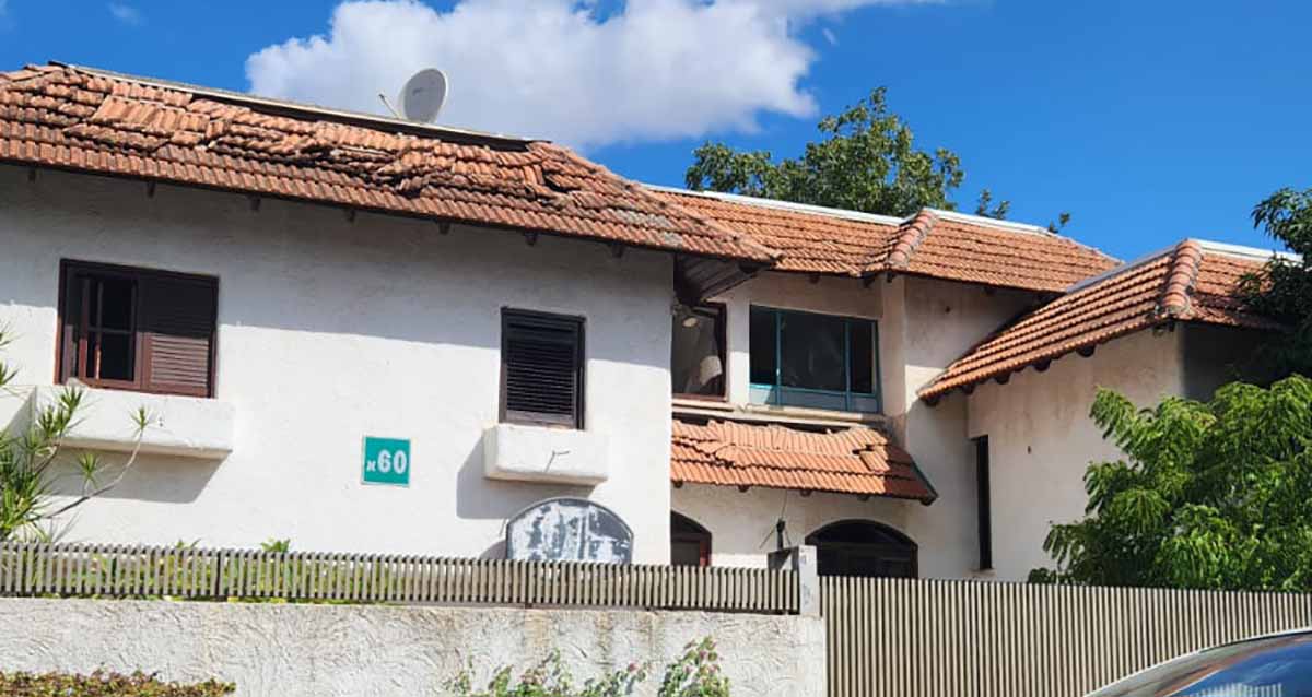 נזקי טילים בהוד השרון בבית פרטי בן שתי קומות עם גג רעפים אדומות. הפגיעה העיקרית בגג הרעפים אשר התנתקו ממקומם והתפזרו על הגג. הבית לבן עם חומה מבטון בחזית. על הבית שלט ירוק עם מספר הבית 60א.