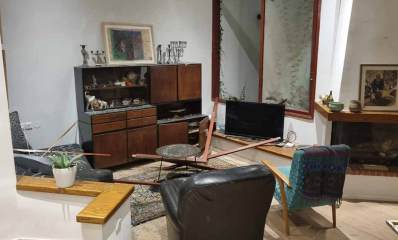 פגיעות הדף של טילים בליסטיים בסלון בית. מסגרת של חלון בתוך הסלון על הרהיטים.