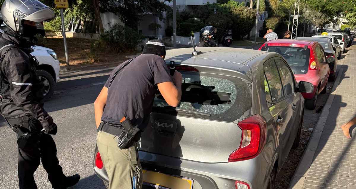 חלק של יירוט נפל על מכונית. שוטר בודק מכונית שהשימשה האחורית שלה שבורה, ולידו עוד שוטר. לפני המכונית חונות עוד מכוניות.