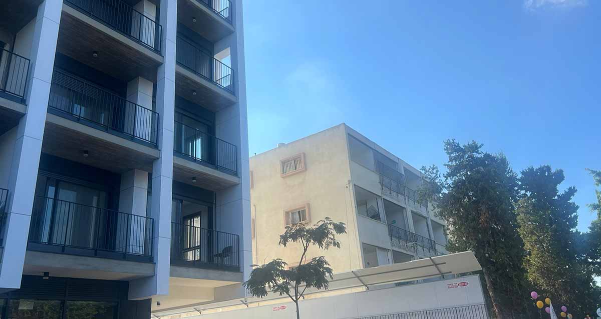 בצד ימין הבניין בשדרות ביאליק 36 לפני הריסה ותמ"א, ובצד שמאל הבניין בשדרות ביאליק 38 אחרי תמ"א. בצד ימין עצים גבוהים.