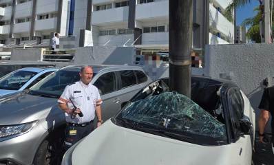 רסיסי יירוט תקועים בגג מכונית חונה במגרש חנייה ברעננה. ליד המכונית איש צוות מד"א