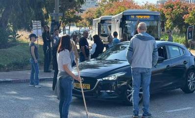 הפגנה בנחל עדה. מפגינים עומדים על הכביש וחוסמים את הכביש לתנועה.מכונית פרטית שחורה עומדת באמצע הכביש ואחריה שני אוטובוסים, ואחריהם עוד שורת מכוניות.