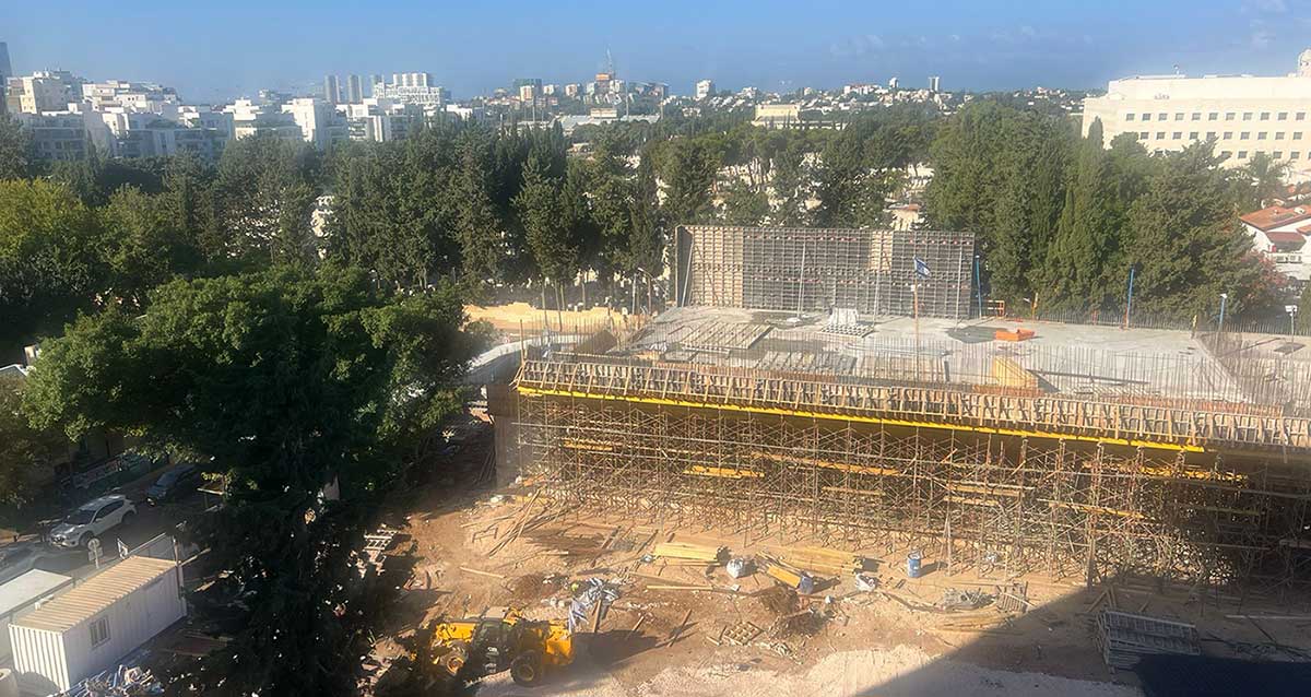אולם הכדורסל בבנייה בבית ספר הנדיב הרצליה. באופק בית הרופאים, ובית העלמין הישן של העיר הרצליה