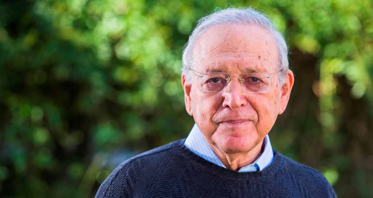 פרופ' אוריאל רייכמן, המייסד הנשיא ויו"ר הדירקטוריון. צילום פנים ופלג גוף עליון. לובש סוודר כחול ומתחתיו חולצה תכלת. שיער אפור ומרכיב משקפי ראייה ללא מסגרת. ברקע צמחייה ירוקה.