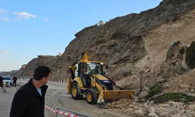 יריב פישר מתבונן בטרקטור שמפנה שברי כורכר מהמצוק שהתמוטט, ברקע אני הפיקוח העירוני