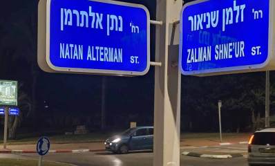 רחוב נתן אלתרמן פינת זלמן שניאור בהרצליה. שלטים כחולים בפינת הרחובות והכיתוב בלבן, בעברית ואנגלית.
