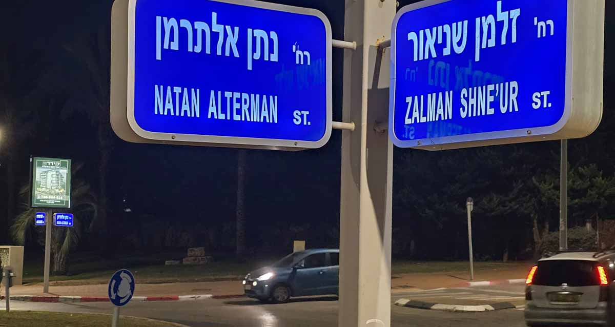 רחוב נתן אלתרמן פינת זלמן שניאור בהרצליה. שלטים כחולים בפינת הרחובות והכיתוב בלבן, בעברית ואנגלית.