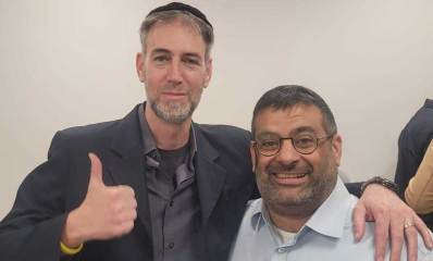 תמונת פלג גוף עליון של חברי מועצת העיר רעננה מאיר גרידיש וחגי פרנקל עומדים חבוקים