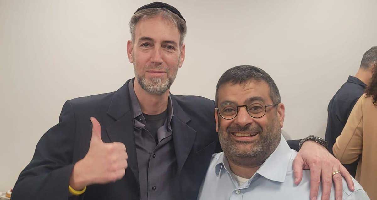 תמונת פלג גוף עליון של חברי מועצת העיר רעננה מאיר גרידיש וחגי פרנקל עומדים חבוקים