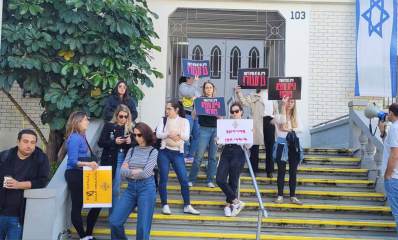 הפגנת אמהות לילדי גן נבל משכונת נווה זמר מחוץ לבניין עיריית רעננה. אמהות עם שלטים על מדרגות הכניסה לבניין העירייה. וגבר אחד עם מיקרופון נייד.