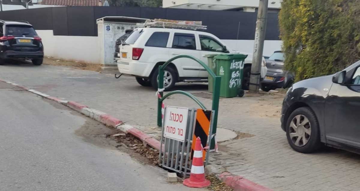 בור בפתח ניקוז על כביש צמוד למדרכה ברחוב נורדאו בהרצליה. הבור מסומן בקונוס זוהר ובמחסום
