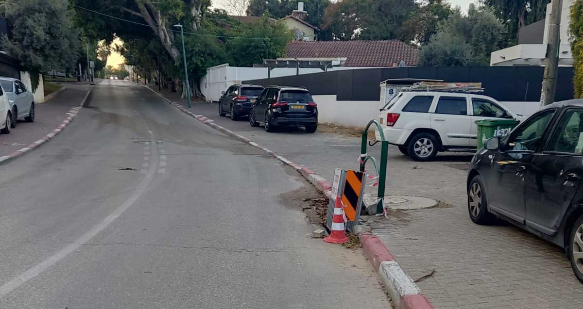 בור בפתח ניקוז על כביש צמוד למדרכה ברחוב נורדאו בהרצליה. הבור מסומן בקונוס זוהר ובמחסום