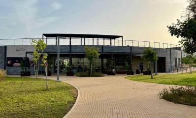 רדיו גליל ים. הבניין בתוך פארק, בניין חד קומתי מעוגל. בחזיתו קיר של זכוכית, וצמחיה בעציצים לפני החזית. בצד שמאל על קיר בטון כיתוב באנגלית: Radio Glil yam.