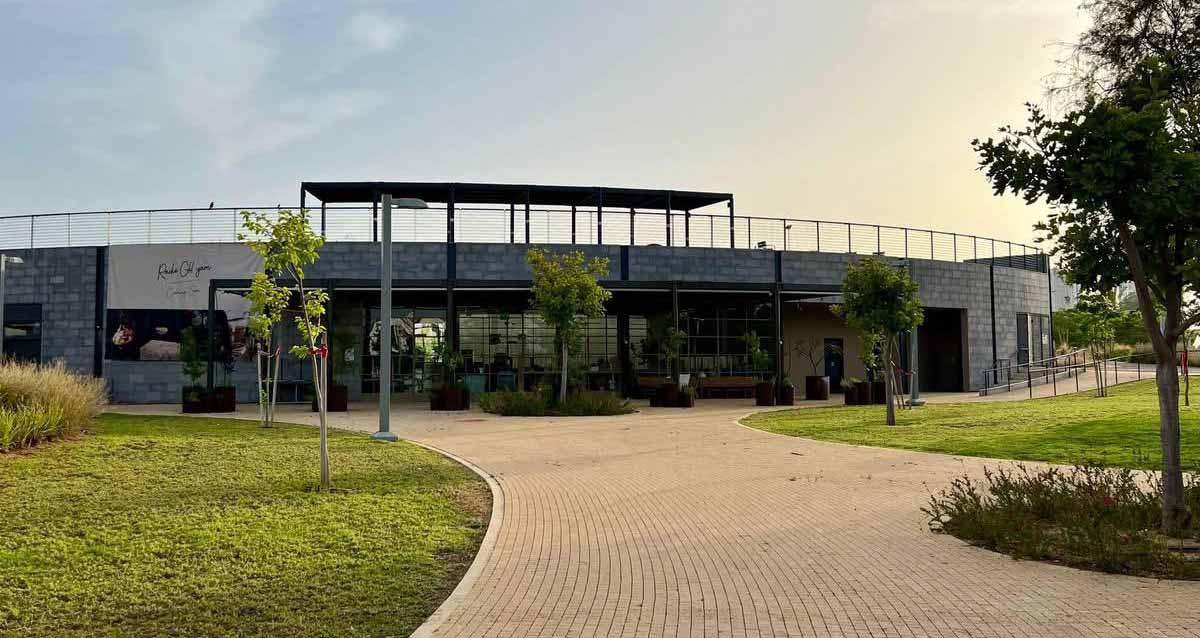 רדיו גליל ים. הבניין בתוך פארק, בניין חד קומתי מעוגל. בחזיתו קיר של זכוכית, וצמחיה בעציצים לפני החזית. בצד שמאל על קיר בטון כיתוב באנגלית: Radio Glil yam.