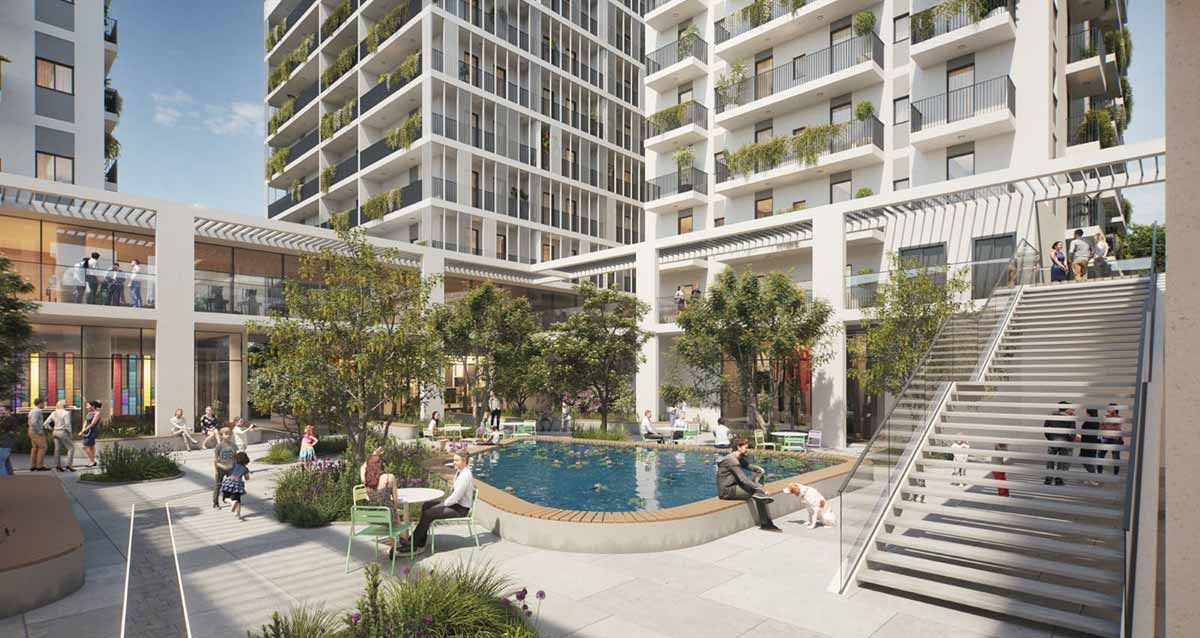 מעונות הסטודנטים המתוכננים בכפר סבא. תמונה של רחבה בין הבניינים עם בריכת נוי, עצים, שולחנות וכסאות. קומה ראשונה עם חנויות. מדרגות לקומה השנייה.